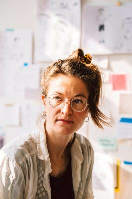 Portrait von einem vollbärtigen Mann mit kurzen Haaren, der in die Kamera lächelt. Er trägt ein Shirt mit einem Fahrrad.