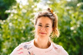 Portrait von einem vollbärtigen Mann mit kurzen Haaren, der in die Kamera lächelt. Er trägt ein Shirt mit einem Fahrrad.