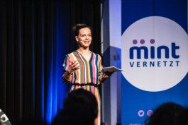 Portrait von einem vollbärtigen Mann mit kurzen Haaren, der in die Kamera lächelt. Er trägt ein Shirt mit einem Fahrrad.