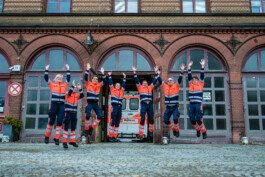 Portrait von einem vollbärtigen Mann mit kurzen Haaren, der in die Kamera lächelt. Er trägt ein Shirt mit einem Fahrrad.