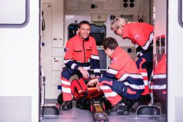 Portrait von einem vollbärtigen Mann mit kurzen Haaren, der in die Kamera lächelt. Er trägt ein Shirt mit einem Fahrrad.