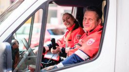 Portrait von einem vollbärtigen Mann mit kurzen Haaren, der in die Kamera lächelt. Er trägt ein Shirt mit einem Fahrrad.