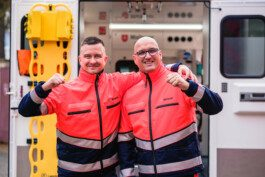 Portrait von einem vollbärtigen Mann mit kurzen Haaren, der in die Kamera lächelt. Er trägt ein Shirt mit einem Fahrrad.