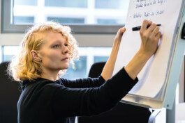 Portrait von einem vollbärtigen Mann mit kurzen Haaren, der in die Kamera lächelt. Er trägt ein Shirt mit einem Fahrrad.
