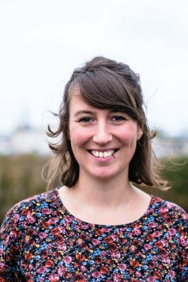 Portrait von einem vollbärtigen Mann mit kurzen Haaren, der in die Kamera lächelt. Er trägt ein Shirt mit einem Fahrrad.