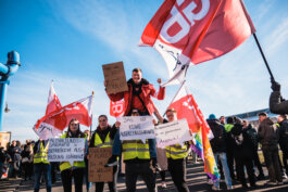 Portrait von einem vollbärtigen Mann mit kurzen Haaren, der in die Kamera lächelt. Er trägt ein Shirt mit einem Fahrrad.
