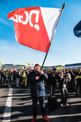Portrait von einem vollbärtigen Mann mit kurzen Haaren, der in die Kamera lächelt. Er trägt ein Shirt mit einem Fahrrad.
