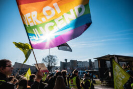 Portrait von einem vollbärtigen Mann mit kurzen Haaren, der in die Kamera lächelt. Er trägt ein Shirt mit einem Fahrrad.